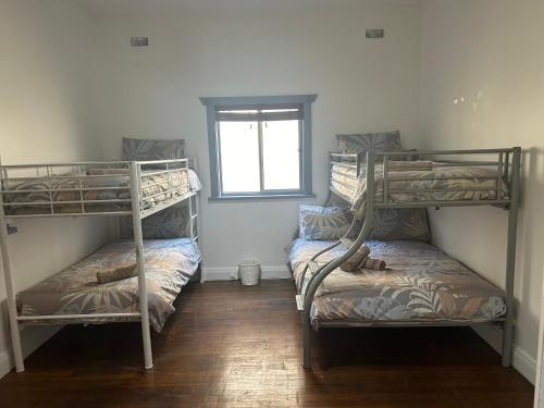 two bunk beds in a room with a window at Full house in the centre of town in Bellingen