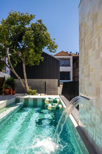 a swimming pool with a fountain in a building at Canto De Luz - Luxury Maison in Porto