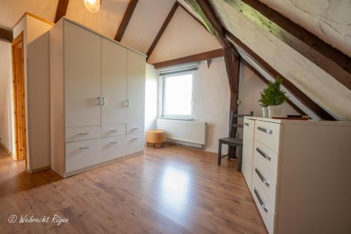 an attic bedroom with white cabinets and a window at Ferienhaus Luppath in Poseritz