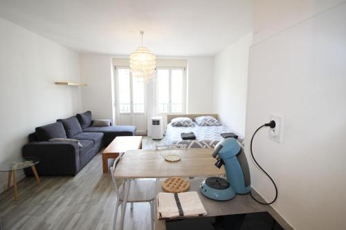 un salon avec un canapé et une table dans l'établissement Verdun Centre - Studio - 1 LIT et canapé convertible - Internet et TV - 4 personnes - Géré par Presta-Zen'Services, à Verdun-sur-Meuse