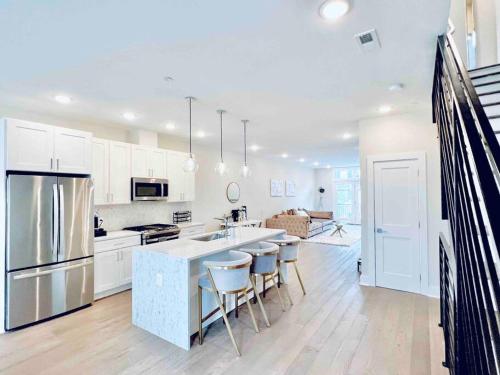 a kitchen with white cabinets and a island with bar stools at Luxurious 3BDR Penthouse with Private Rooftop Capitol and Monument Views Near Popular H Street Corridor Free Parking and Cancellation in Washington, D.C.