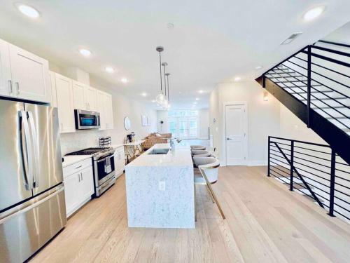a large kitchen with white cabinets and a staircase at Luxurious 3BDR Penthouse with Private Rooftop Capitol and Monument Views Near Popular H Street Corridor Free Parking and Cancellation in Washington, D.C.