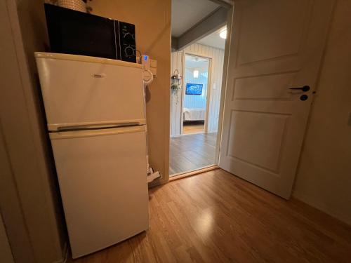 a white refrigerator with a microwave on top of it at Bratsberg Apartment - with Kitchenette and Free Parking in Trondheim