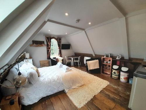a bedroom with a large bed in a attic at Quaint Studio Loft Room nr Hampton Court in Thames Ditton