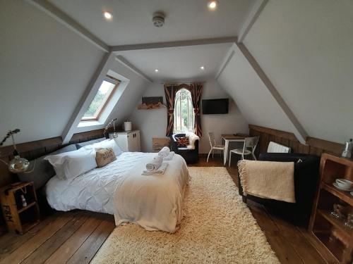 a bedroom with a large bed in a attic at Quaint Studio Loft Room nr Hampton Court in Thames Ditton
