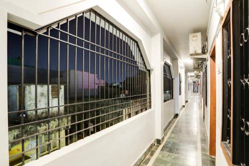 a corridor of a building with windows with black bars at Hotel O Shree Ram Residency in Cuttack