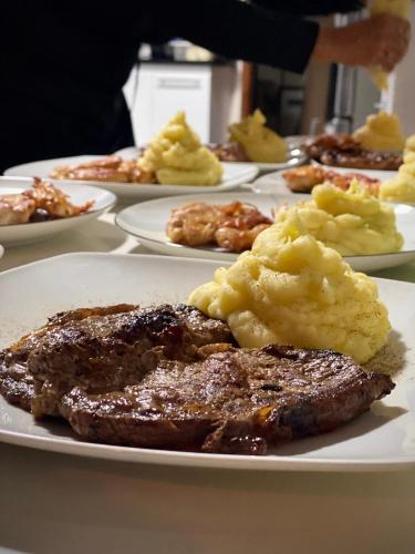 a plate of food with steak and mashed potatoes on a table at Ololó Caracas B&B in Chacao