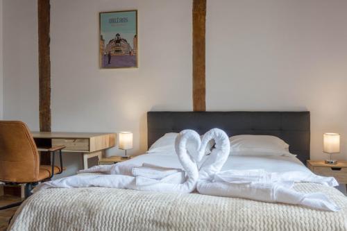 2 serviettes de cygne sont pliées sur un lit dans l'établissement ORLEANS CENTRE HISTORIQUE - Charmant T2 - L'EVASION ORLEANAISE, à Orléans