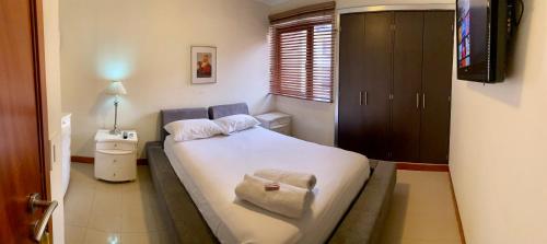 a small bedroom with a bed and a television at Ololó Caracas B&B in Chacao