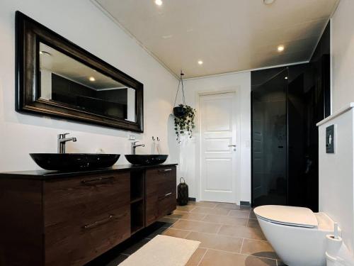 a bathroom with two sinks and a large mirror at Modern Vacation Home With Hot Tub in Froðba