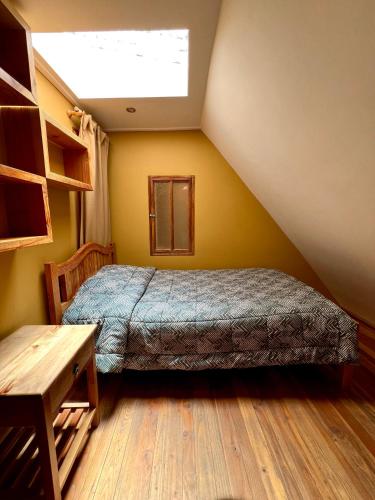 a bedroom with a bed and a wooden floor at Hostal Corvatsch Chile in San Pedro de Atacama