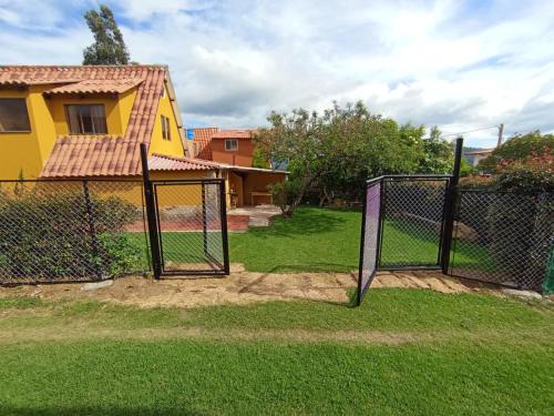 a chain link fence in front of a house at Cabaña Villa Makus in Paipa