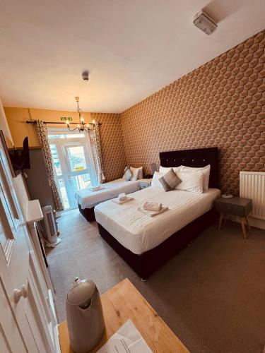 a hotel room with two beds and a television at The Central Hotel in Llandudno