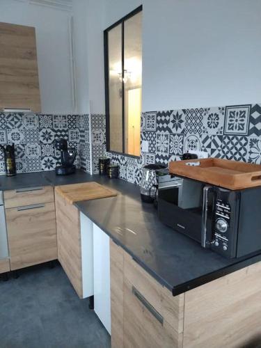 une cuisine avec un comptoir avec un micro-ondes dans l'établissement Appartement vue sur château fort de Lourdes, à Lourdes