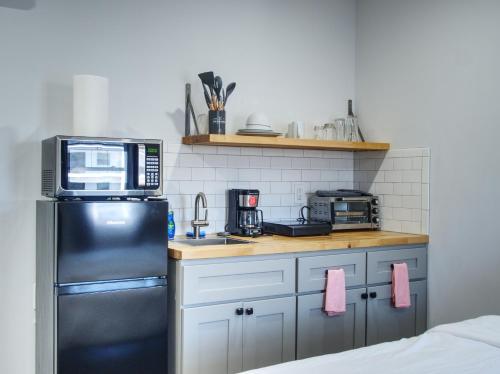 a kitchen with a black refrigerator and a microwave at Vermont Suites in South Burlington