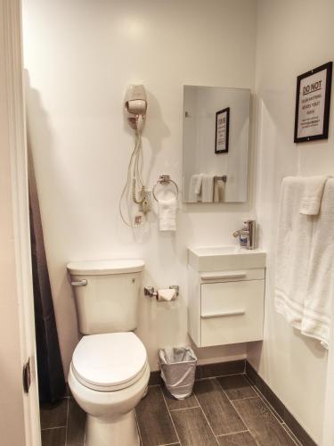 a bathroom with a toilet and a phone on the wall at Vermont Suites in South Burlington