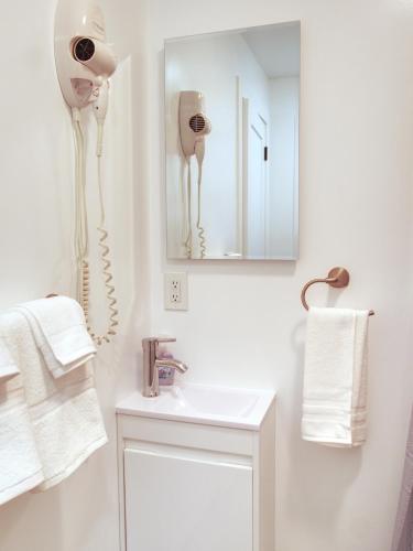 a white bathroom with a phone on the wall at Vermont Suites in South Burlington