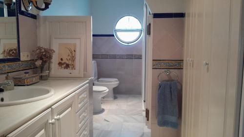a bathroom with a sink and a toilet and a window at Az-zait in Aznalcázar