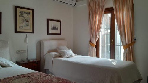a bedroom with two beds and a window at Az-zait in Aznalcázar