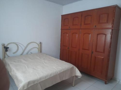 - une chambre avec un lit et une grande armoire en bois dans l'établissement Chácara Sagrada Família, à Cachoeira Paulista