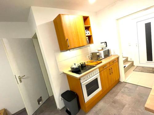 a small kitchen with wooden cabinets and a stove at RobinsHomes saniertes Reihenhaus in BS in Braunschweig