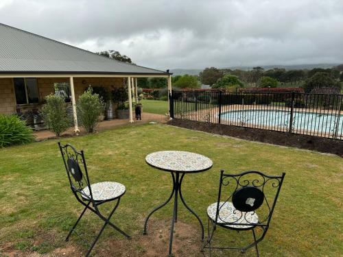 a table and two chairs in a yard at Barossa Garden Homestay in Williamstown