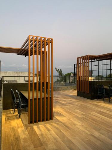 a wooden deck with a table and chairs on a roof at Flat João Pessoa na praia do Bessa in Tambaú