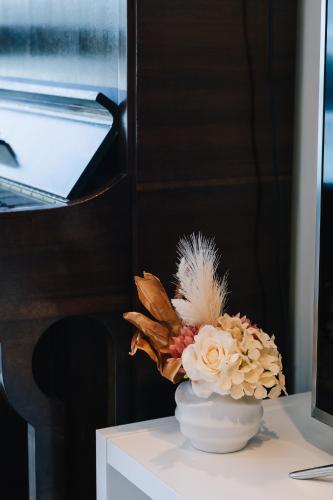 a vase with flowers on a table next to a piano at breathtaking Fortitude valley Apartment in Brisbane