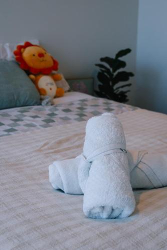 a pile of towels on a bed with a stuffed animal at breathtaking Fortitude valley Apartment in Brisbane