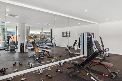 a gym with a large mirror and lots of exercise equipment at breathtaking Fortitude valley Apartment in Brisbane