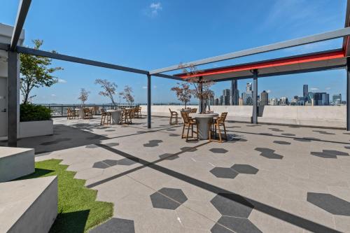 a patio with tables and chairs with a view of the city at breathtaking Fortitude valley Apartment in Brisbane