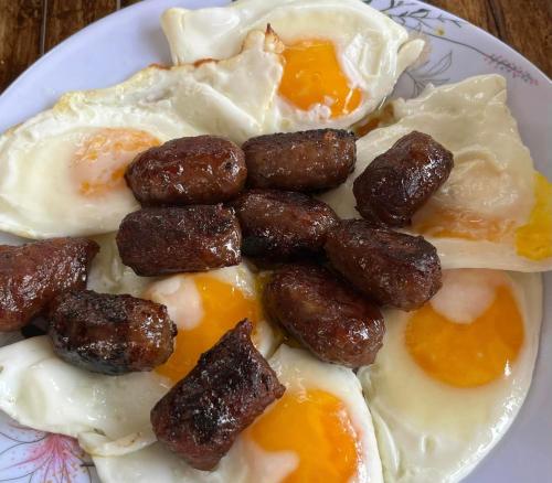 ein Frühstücksteller mit Eiern und Wurst in der Unterkunft Gensan Hostel in General Santos