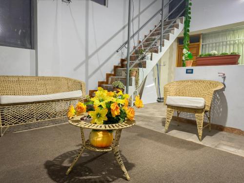 a room with a table with a vase of flowers on it at Bellavista House Puno in Puno