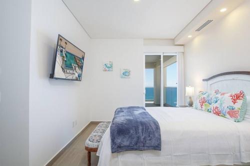ein weißes Schlafzimmer mit einem großen Bett und einem Fenster in der Unterkunft Encantame Towers 2 -Bedroom Luxury DLX Verano E905- Corner Balcony in Playa Encanto