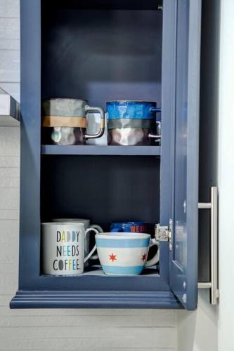 a blue cabinet with bowls and cups in it at Stylish 2BR stunner in unbeatable location in Chicago