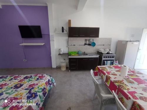 a bedroom with a bed and a kitchen with purple walls at Josefina l in Goya