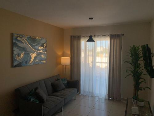 a living room with a couch and a window at Depa playa esmeralda in Altata