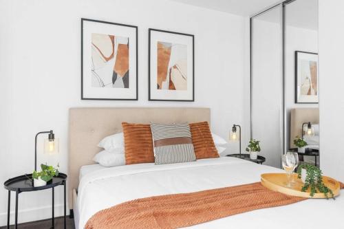a bedroom with a large white bed with three pictures at Hidden Gem at Caulfield Park in Melbourne