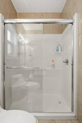 a shower with a glass door in a bathroom at Large Detached Near Anthony Henday in Albany with 2 Living Rooms, Netflix, Office Space, AC, Perfect for Families, Sleeps 13 in Edmonton