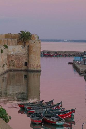 a group of boats in the water next to a building at Art riad au bord de la mer 1 in El Jadida