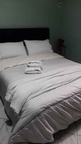 a bed with three towels stacked on top of it at Casa espaçosa bem localizada em Maricá! in Maricá