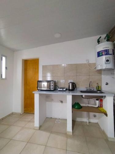 a kitchen with a counter with a microwave and a sink at Casa Alma San Pedro in San Pedro