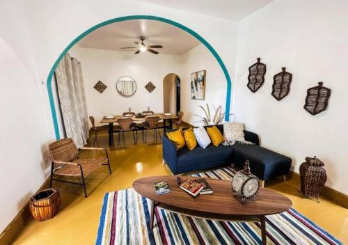 a living room with a blue couch and a table at Centrally Located Beach and Restaurant Centric in Cabo Rojo