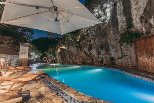 ein großer Pool mit Sonnenschirm und Stühlen in der Unterkunft Bamboo Hill Villa in Ninh Bình