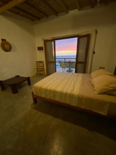 a bedroom with a bed and a view of the ocean at Altavista Casa de Huespedes in Vichayito