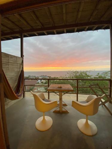 a table and chairs on a balcony with a view at Altavista Casa de Huespedes in Vichayito