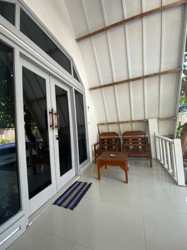 a screened in porch with two chairs and a table at LUCKY'S in Gili Air