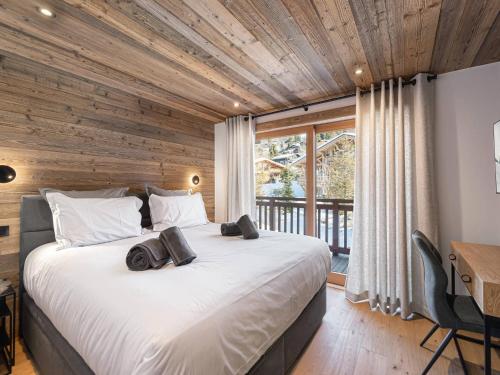 une chambre avec un grand lit avec un plafond en bois dans l'établissement Charmant appartement au centre avec sauna et balcon à Megève - FR-1-569-114, à Megève