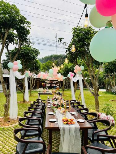 a long table set up for a party with balloons at TRA LINH HOTEL & RESTAURANTs in Hữu Lũng