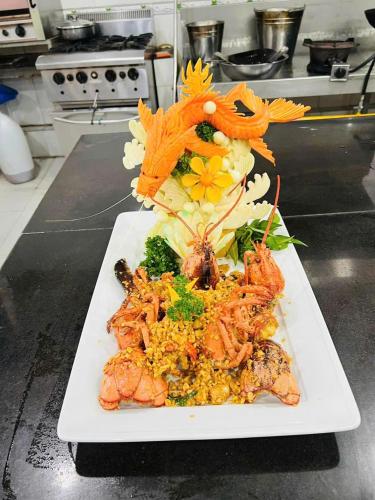 a plate of food with seafood and rice on a counter at TRA LINH HOTEL & RESTAURANTs in Hữu Lũng